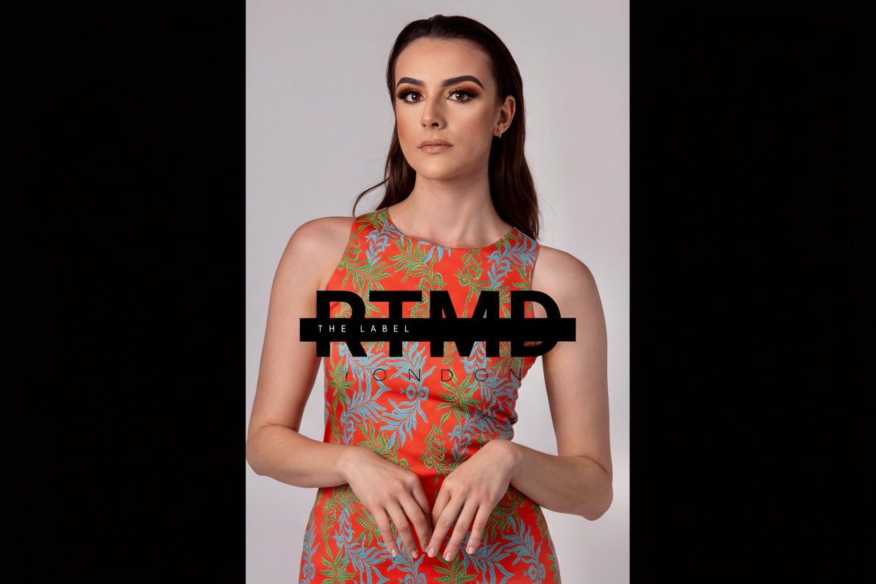Woman wearing a colorful dress with 'RTMD' branding on a plain background